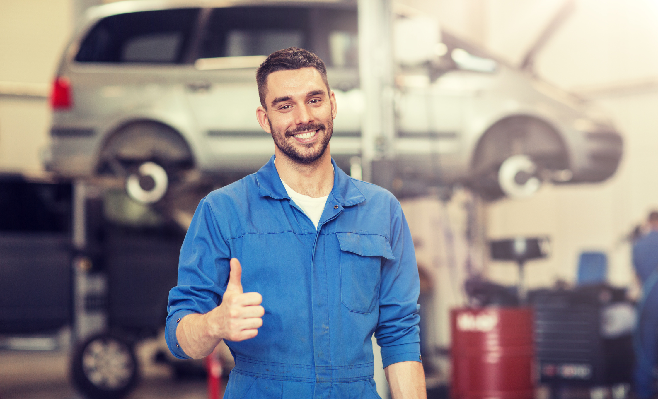 Happy Auto Mechanic Man at Car Workshop